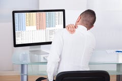 Uomo d'affari With Shoulder Pain che per mezzo del computer fotografia stock Uomo d'affari With Shoulder Pain che per mezzo del computer fotografia stock