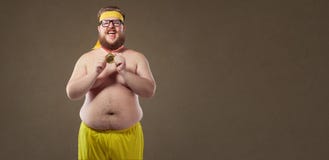 Uomo divertente spesso con una medaglia in sue mani immagini stock Uomo divertente spesso con una medaglia in sue mani immagini stock