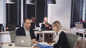 Uomo facendo uso del computer portatile e della discussione del progetto nuovo con la donna video d archivio Uomo facendo uso del computer portatile e della discussione del progetto nuovo con la donna video d archivio