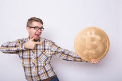 Uomo felice di affari che tiene grande bitcoin dorato su fondo bianco Valuta cripto, soldi virtuali, Internet e Fotografia Stock Libera da Diritti Uomo felice di affari che tiene grande bitcoin dorato su fondo bianco Valuta cripto, soldi virtuali, Internet e Fotografia Stock Libera da Diritti
