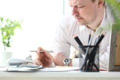 Uomo maturo che lavora con il calcolatore che valuta le opportunità finanziarie per la vacanza di famiglia fotografie stock Uomo maturo che lavora con il calcolatore che valuta le opportunità finanziarie per la vacanza di famiglia fotografie stock