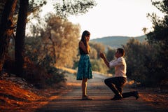 Uomo nell'amore che propone una donna sorpresa e colpita sposarlo Concetto di proposta, di impegno e di nozze betrothal Essendo a immagini stock libere da diritti Uomo nell'amore che propone una donna sorpresa e colpita sposarlo Concetto di proposta, di impegno e di nozze betrothal Essendo a immagini stock libere da diritti