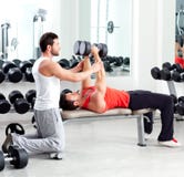 Uomo personale dell'addestratore di ginnastica con addestramento del peso fotografia stock Uomo personale dell'addestratore di ginnastica con addestramento del peso fotografia stock