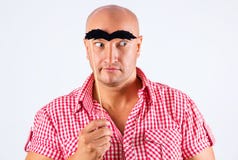 Uomo positivo con le sopracciglia false, fondo bianco con lo sguardo sorpreso fotografia stock Uomo positivo con le sopracciglia false, fondo bianco con lo sguardo sorpreso fotografia stock