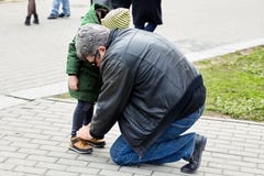 Uomo senior che lega i pizzi sugli stivali di un bambino Il padre o il nonno aiuta il suo piccolo figlio o nipote L'entrambi dura fotografie stock libere da diritti Uomo senior che lega i pizzi sugli stivali di un bambino Il padre o il nonno aiuta il suo piccolo figlio o nipote L'entrambi dura fotografie stock libere da diritti