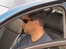 Uomo serio nella finestra di automobile fotografia stock Uomo serio nella finestra di automobile fotografia stock