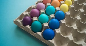 Uova di Pasqua variopinte tinte mano vibrante in una scatola delle uova del cartone osservata fotografie stock libere da diritti Uova di Pasqua variopinte tinte mano vibrante in una scatola delle uova del cartone osservata fotografie stock libere da diritti