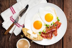 Uova fritte, bacon e pane italiano di ciabatta sul piatto bianco Tazza di caffè Vista superiore della prima colazione Priorità ba immagine stock libera da diritti Uova fritte, bacon e pane italiano di ciabatta sul piatto bianco Tazza di caffè Vista superiore della prima colazione Priorità ba immagine stock libera da diritti