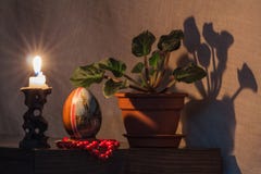 Uovo di Pasqua su un fondo scuro nel lume di candela immagine stock Uovo di Pasqua su un fondo scuro nel lume di candela immagine stock