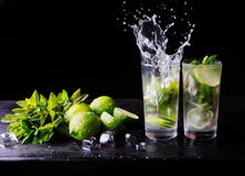 Uppfriskande lemonad för sommarcoctailmojito med färgstänk Particoctail Limefrukt, is och mintkaramell på tabellen _ arkivbild Uppfriskande lemonad för sommarcoctailmojito med färgstänk Particoctail Limefrukt, is och mintkaramell på tabellen _ arkivbild