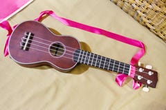 Uquelele com a alça cor-de-rosa da fita no backgrou do colchão fotos de stock Uquelele com a alça cor-de-rosa da fita no backgrou do colchão fotos de stock