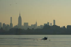 Urban landscape of skyscrapers of Manhattan, New York, with cutter running and birds flying low above the water ahead stock photography Urban landscape of skyscrapers of Manhattan, New York, with cutter running and birds flying low above the water ahead stock photography