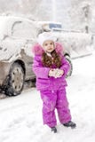 Urocza dzieciak dziewczyna z samochodem zakrywającym śniegiem na tle obrazy stock Urocza dzieciak dziewczyna z samochodem zakrywającym śniegiem na tle obrazy stock