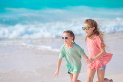 Urocze małe dziewczynki zabawę na białej tropikalnej plaży wpólnie obrazy stock Urocze małe dziewczynki zabawę na białej tropikalnej plaży wpólnie obrazy stock