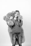 Urso de peluche grande do abraço da menina no fundo alaranjado Foto de Stock Urso de peluche grande do abraço da menina no fundo alaranjado Foto de Stock