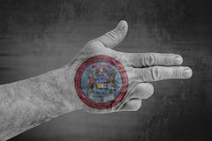 US State Michigan Seal flag painted on male hand like a gun royalty free illustration US State Michigan Seal flag painted on male hand like a gun royalty free illustration