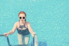 Uscire della donna dell'acqua blu nello stagno fotografie stock Uscire della donna dell'acqua blu nello stagno fotografie stock
