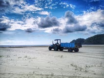 Beach cleaning and a tractor used to remove beach debris and dark cloudy sky above. stock images Beach cleaning and a tractor used to remove beach debris and dark cloudy sky above. stock images