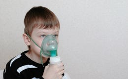 Use nebulizer and inhaler for the treatment. Boy inhaling through inhaler mask. Front view stock image Use nebulizer and inhaler for the treatment. Boy inhaling through inhaler mask. Front view stock image