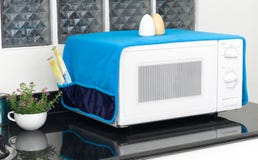 Microwave oven with the cover blanket to protect dust or dirty Royalty Free Stock Photo Microwave oven with the cover blanket to protect dust or dirty Royalty Free Stock Photo
