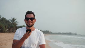 Uso audio ai del reconocimiento vocal del mensaje del hombre del uso del smartphone turístico joven hermoso del teléfono durante almacen de video Uso audio ai del reconocimiento vocal del mensaje del hombre del uso del smartphone turístico joven hermoso del teléfono durante almacen de video