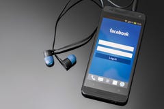 Uso de Facebook en la pantalla elegante del teléfono. fotografía de archivo Uso de Facebook en la pantalla elegante del teléfono. fotografía de archivo
