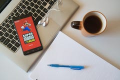 Uso estupendo del juego de Mario en smartphone imagen de archivo Uso estupendo del juego de Mario en smartphone imagen de archivo