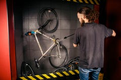 Usługuje fachowego domycie bicykl w warsztacie Młody caucasian elegancki mężczyzna z długim kędzierzawym włosy robi rowerowemu cl fotografia royalty free Usługuje fachowego domycie bicykl w warsztacie Młody caucasian elegancki mężczyzna z długim kędzierzawym włosy robi rowerowemu cl fotografia royalty free