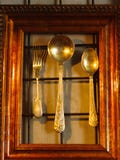 Utensílio brilhante em um fundo da parede Colheres de prata e pouco para imagem de stock Utensílio brilhante em um fundo da parede Colheres de prata e pouco para imagem de stock