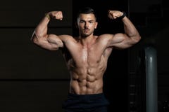 Utf?rande Front Double Biceps Pose In f?r kroppsbyggare idrottshall arkivbilder Utf?rande Front Double Biceps Pose In f?r kroppsbyggare idrottshall arkivbilder