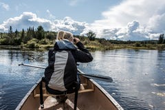 Utilisation de fille binoculaire sur le lac canoe de deux rivières dans le parc national d'algonquin dans le Canada d'Ontario le images libres de droits Utilisation de fille binoculaire sur le lac canoe de deux rivières dans le parc national d'algonquin dans le Canada d'Ontario le images libres de droits