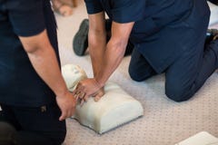 Utilisation de formation de CPR et une valve de masque d'AED et de sac sur un mannequin adulte de formation photographie stock libre de droits Utilisation de formation de CPR et une valve de masque d'AED et de sac sur un mannequin adulte de formation photographie stock libre de droits