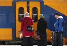 Utrecht, los Países Bajos, el 15 de febrero de 2019: Tres personas que viajan con el tren y que esperan las puertas para abrirse imágenes de archivo libres de regalías Utrecht, los Países Bajos, el 15 de febrero de 2019: Tres personas que viajan con el tren y que esperan las puertas para abrirse imágenes de archivo libres de regalías