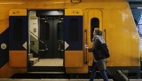 Utrecht, Нидерланд, 15-ое февраля 2019: Женщина улавливая поезд междугородний от NS с чашкой кофе стоковые фотографии rf Utrecht, Нидерланд, 15-ое февраля 2019: Женщина улавливая поезд междугородний от NS с чашкой кофе стоковые фотографии rf