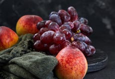 Uva e pesche su un fondo scuro fotografie stock libere da diritti Uva e pesche su un fondo scuro fotografie stock libere da diritti