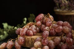 Uva in un vaso a cristallo, con un bicchiere di vino su un fondo nero fotografie stock libere da diritti Uva in un vaso a cristallo, con un bicchiere di vino su un fondo nero fotografie stock libere da diritti