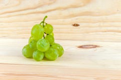 Uvas no fundo de madeira imagem de stock Uvas no fundo de madeira imagem de stock