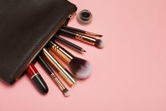 Uzupełnia torbę z kosmetykami odizolowywającymi na różowym tle zdjęcia stock Uzupełnia torbę z kosmetykami odizolowywającymi na różowym tle zdjęcia stock