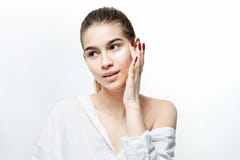 Uśmiechnięta młoda brązowowłosa dziewczyna bez makeup ubierającego w biel ubraniach stawia śmietankę na jej twarzy na białym tle obrazy stock Uśmiechnięta młoda brązowowłosa dziewczyna bez makeup ubierającego w biel ubraniach stawia śmietankę na jej twarzy na białym tle obrazy stock