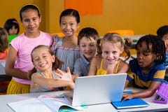 Uśmiechnięci wielo- etniczni dzieci używa laptop zdjęcia royalty free Uśmiechnięci wielo- etniczni dzieci używa laptop zdjęcia royalty free