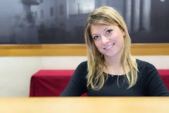 Uśmiechnięta dziewczyna na recepcyjnym biurku fotografia stock Uśmiechnięta dziewczyna na recepcyjnym biurku fotografia stock