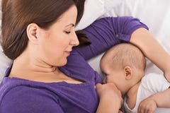 Uśmiechnięta szczęśliwa matka breastfeeding jej dziecko niemowlaka zdjęcie royalty free Uśmiechnięta szczęśliwa matka breastfeeding jej dziecko niemowlaka zdjęcie royalty free