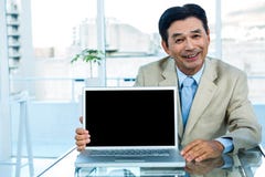 Uśmiechnięty azjatykci biznesmen pokazuje laptop Zdjęcia Stock Uśmiechnięty azjatykci biznesmen pokazuje laptop Zdjęcia Stock