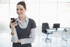Uśmiechnięty bizneswoman trzyma jej smartphone pozować Obraz Royalty Free Uśmiechnięty bizneswoman trzyma jej smartphone pozować Obraz Royalty Free