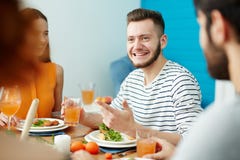 Uśmiechnięty mężczyzna opowiada przyjaciele podczas gdy jedzący wpólnie zdjęcia royalty free Uśmiechnięty mężczyzna opowiada przyjaciele podczas gdy jedzący wpólnie zdjęcia royalty free