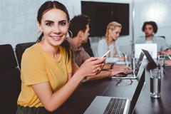 uśmiechnięty młody bizneswoman z smartphone i ona partnery ma dyskusję za nowożytnym przy zdjęcie royalty free uśmiechnięty młody bizneswoman z smartphone i ona partnery ma dyskusję za nowożytnym przy zdjęcie royalty free