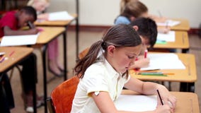 Uśmiechnięty uczeń robi ćwiczeniom zbiory Uśmiechnięty uczeń robi ćwiczeniom zbiory