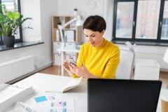 Uśmiechnięty ui projektant używa smartphone przy biurem zdjęcie stock Uśmiechnięty ui projektant używa smartphone przy biurem zdjęcie stock