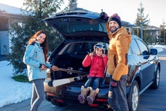 Vacanza di inverno Tempo della famiglia all'aperto che sta insieme vicino all'automobile che mette l'attrezzatura dello sci nel s immagini stock Vacanza di inverno Tempo della famiglia all'aperto che sta insieme vicino all'automobile che mette l'attrezzatura dello sci nel s immagini stock