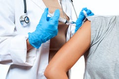 Vaccination. Doctor injecting flu vaccine to patient`s arm.